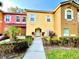 Charming two-story townhome featuring colorful exteriors, manicured landscaping, and a welcoming entrance at 2788 Sun Key Pl, Kissimmee, FL 34747