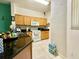 Efficient kitchen with dark countertops, wood cabinets, and essential appliances for easy meal preparation at 2788 Sun Key Pl, Kissimmee, FL 34747