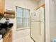 Practical kitchen area featuring a refrigerator, spice rack, and tile flooring for easy maintenance at 2788 Sun Key Pl, Kissimmee, FL 34747