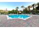 Relaxing outdoor pool area lined with lounge chairs and mature palm trees at 2788 Sun Key Pl, Kissimmee, FL 34747