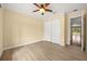 Inviting bedroom featuring wood flooring, ceiling fan, closet and access door to patio at 2841 S Lloyd Ln, Kissimmee, FL 34744