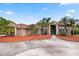 Spacious brick home with a circular driveway, palm trees, manicured landscaping, and a grand entrance with oversized columns at 2841 S Lloyd Ln, Kissimmee, FL 34744