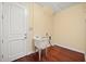 Bright laundry room features a utility sink, dark hardwood floors, and a white door at 2841 S Lloyd Ln, Kissimmee, FL 34744