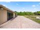 Spacious brick patio area with view of lush yard, pond, and mature trees at 2841 S Lloyd Ln, Kissimmee, FL 34744