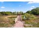 A pond with a wooden bridge leading to a gazebo surrounded by lush greenery at 2841 S Lloyd Ln, Kissimmee, FL 34744