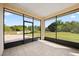 Screened-in porch with tiled floor and views of the backyard and mature trees at 2841 S Lloyd Ln, Kissimmee, FL 34744