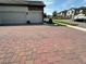 Wide view of a brick driveway with well-maintained lawns and neighboring homes in the background at 2920 Agostino Ter, Kissimmee, FL 34746