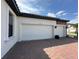Attached two-car garage with white doors, black carriage lights, and brick accents at 2920 Agostino Ter, Kissimmee, FL 34746