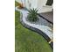 Landscaping with gravel, rocks, tropical plants, and black decorative border enhance the home's curb appeal at 2920 Agostino Ter, Kissimmee, FL 34746