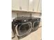 Efficient laundry area featuring a modern washer and dryer, and ample cabinet storage above at 2920 Agostino Ter, Kissimmee, FL 34746