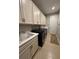 Convenient laundry room with modern appliances, sink, ample cabinetry, and a tiled floor at 2920 Agostino Ter, Kissimmee, FL 34746