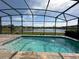 Inviting screened-in pool with a tranquil lake view, perfect for relaxation and entertainment at 2920 Agostino Ter, Kissimmee, FL 34746
