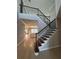 Elegant staircase with wood and iron railings overlooking an open living space, enhancing the home's architectural design at 2920 Agostino Ter, Kissimmee, FL 34746