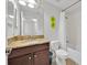 Cozy bathroom featuring a granite countertop, dark wood cabinet, and shower-tub combo at 2985 Banana Palm Dr, Kissimmee, FL 34747