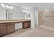 Bright bathroom featuring a double vanity with granite countertops and a glass-enclosed shower at 2985 Banana Palm Dr, Kissimmee, FL 34747