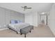 This bedroom features carpet flooring, a modern bed, and an ottoman at the end of the bed at 2985 Banana Palm Dr, Kissimmee, FL 34747