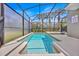 Inviting pool area with crystal-clear water and lush greenery, enclosed by a screened-in lanai for year-round enjoyment at 2985 Banana Palm Dr, Kissimmee, FL 34747