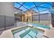 A screened pool with an attached spa, providing a relaxing retreat in a private backyard setting at 2985 Banana Palm Dr, Kissimmee, FL 34747