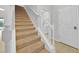 Carpeted staircase with white railing leads to the upper level, with a door leading to the laundry area at 2985 Banana Palm Dr, Kissimmee, FL 34747