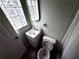 Bathroom featuring a white vanity and toilet, complemented by a unique glass block window for natural light at 31 S Edgemon Ave, Winter Springs, FL 32708