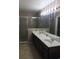 This bathroom features a double sink vanity, shower, tile floors, and a large mirror at 3102 Westbrook Rd, Kissimmee, FL 34746