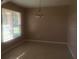 Vacant dining room with chandelier, neutral walls, tiled floor, and natural light from window at 3102 Westbrook Rd, Kissimmee, FL 34746