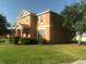 Side view of a two-story house with a well-kept lawn and lush greenery at 3102 Westbrook Rd, Kissimmee, FL 34746