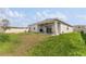 Spacious backyard with lush green grass, a covered patio, and a privacy fence at 33263 Rembrandt Ln, Sorrento, FL 32776