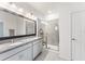 Modern bathroom with double sinks, granite countertop, a large mirror, and a glass-enclosed shower with tiled walls at 33263 Rembrandt Ln, Sorrento, FL 32776