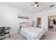 Cozy bedroom with neutral carpet, a ceiling fan, a bed with patterned bedding, and natural light from a window at 33263 Rembrandt Ln, Sorrento, FL 32776