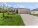 Charming single-story home featuring a manicured lawn, stone accents, and a two-car garage at 33263 Rembrandt Ln, Sorrento, FL 32776
