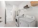 Clean laundry room featuring tile flooring, modern washer and dryer, and ample shelving for storage at 33263 Rembrandt Ln, Sorrento, FL 32776