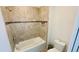 Cozy bathroom featuring a tub with tiled wall and a toilet at 349 Captiva Dr, Davenport, FL 33896
