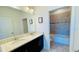 Well-lit bathroom with a double sink vanity, a large mirror, and tiled tub at 349 Captiva Dr, Davenport, FL 33896