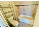Cozy bathroom featuring a tub with tiled wall and a toilet with storage shelves at 349 Captiva Dr, Davenport, FL 33896