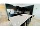 Sleek kitchen features an island with seating, modern appliances, and dark cabinets at 349 Captiva Dr, Davenport, FL 33896