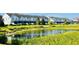 Picturesque view of townhomes overlooking a peaceful pond, enhanced by vibrant green landscaping at 349 Captiva Dr, Davenport, FL 33896