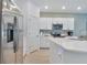 White kitchen features modern appliances, sleek cabinetry and a view of the open floor plan at 3617 Anibal St, Kissimmee, FL 34746
