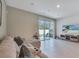 Living room featuring a plush sectional sofa, media console, and sliding glass doors leading to the backyard at 3617 Anibal St, Kissimmee, FL 34746