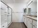 Bright bathroom featuring dual sinks, tile flooring, and a glass shower at 3690 Maidencain St, Clermont, FL 34714