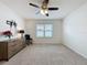 Sunlit bedroom featuring a ceiling fan, view of the outside, and neutral carpet at 3690 Maidencain St, Clermont, FL 34714