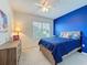 Cozy bedroom with plush carpeting, a comfortable queen-sized bed, and a bright accent wall at 3690 Maidencain St, Clermont, FL 34714