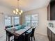 Bright dining area featuring a marble table set for eight with glass accents and sliding glass door access at 3690 Maidencain St, Clermont, FL 34714