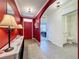 Bright foyer with tile flooring, arched entryway, and adjacent bathroom with a red accent wall at 3690 Maidencain St, Clermont, FL 34714
