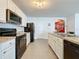 Well-lit kitchen features modern appliances, including a black range, microwave, and refrigerator against neutral countertops at 3690 Maidencain St, Clermont, FL 34714