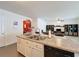 Bright kitchen area with view into living space, featuring a double basin sink and a breakfast bar at 3690 Maidencain St, Clermont, FL 34714