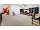 Open-concept living space features a large custom entertainment center, neutral carpet, and barstool seating at 3690 Maidencain St, Clermont, FL 34714