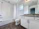 Bright, white bathroom with tiled shower-tub combination, decorative tile flooring, and granite countertop vanity at 394 Orange Cosmos Blvd, Davenport, FL 33837