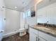 A well-lit bathroom with a walk-in shower, a window, and a granite vanity at 394 Orange Cosmos Blvd, Davenport, FL 33837