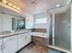 Bathroom with walk-in shower, soaker tub and vanity sinks with granite countertops at 394 Orange Cosmos Blvd, Davenport, FL 33837